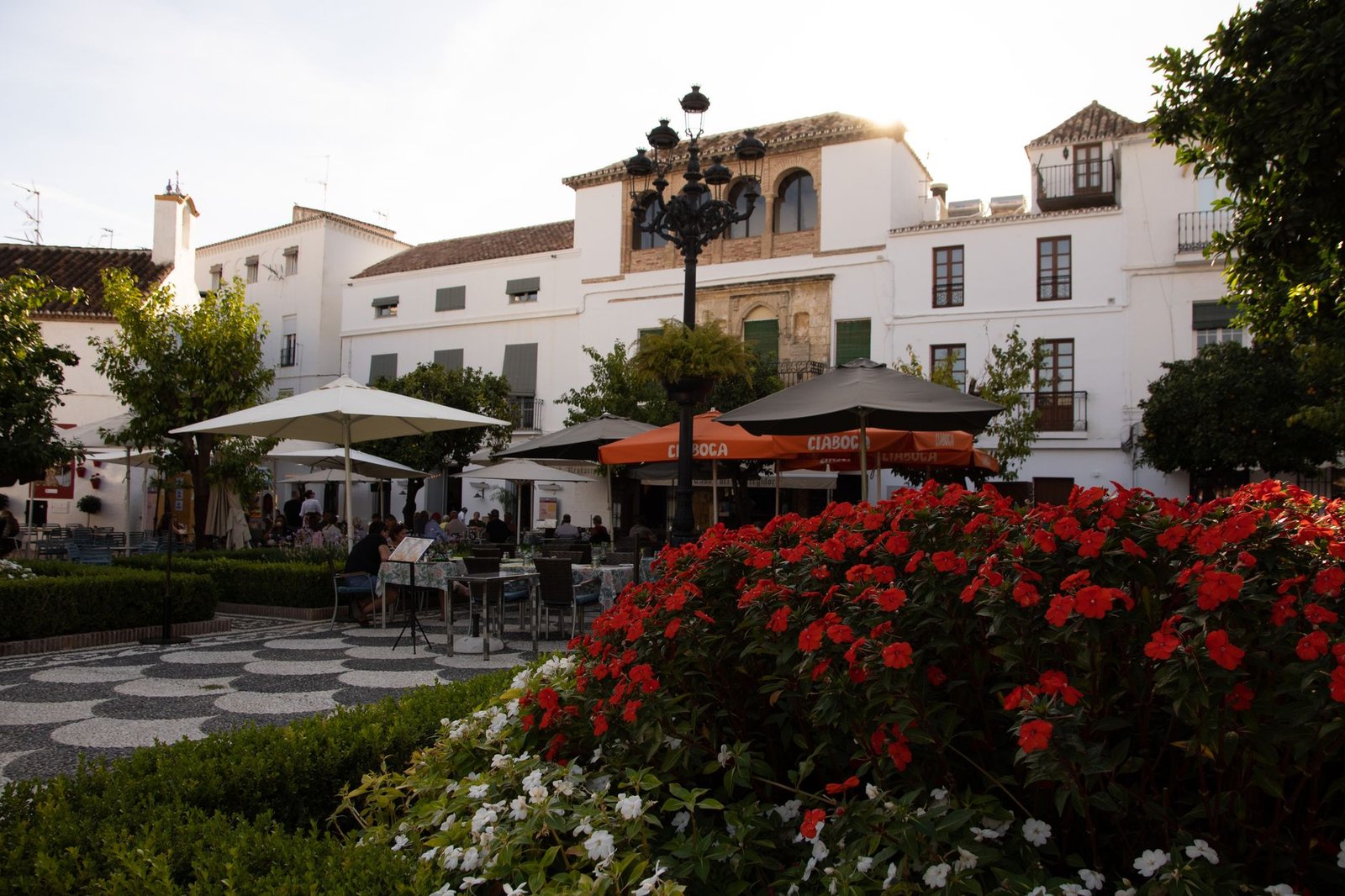 outdoor cafe with flowers and umbrellas in a European courtyard