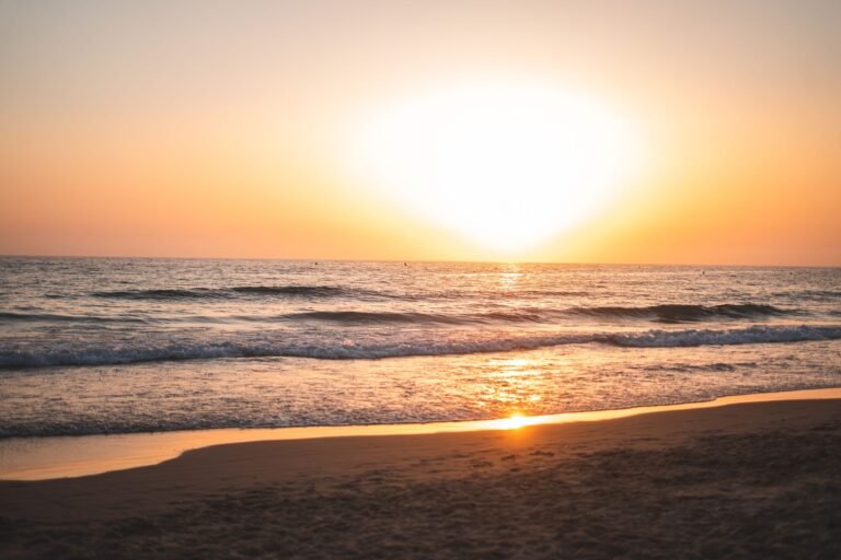 sunset vista over Cádiz beach with gentle waves and golden sky reflection
