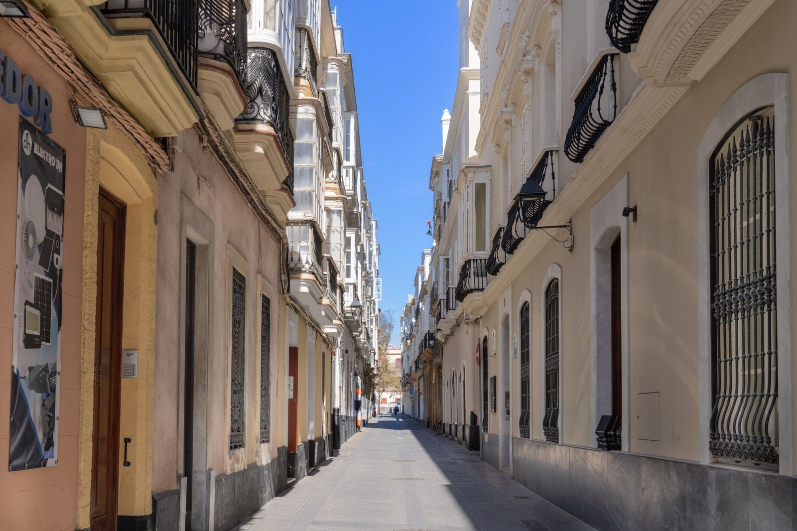 A beautiful narrow street in Cádiz, Spain, showcasing classic Andalucían architecture on a sunny day