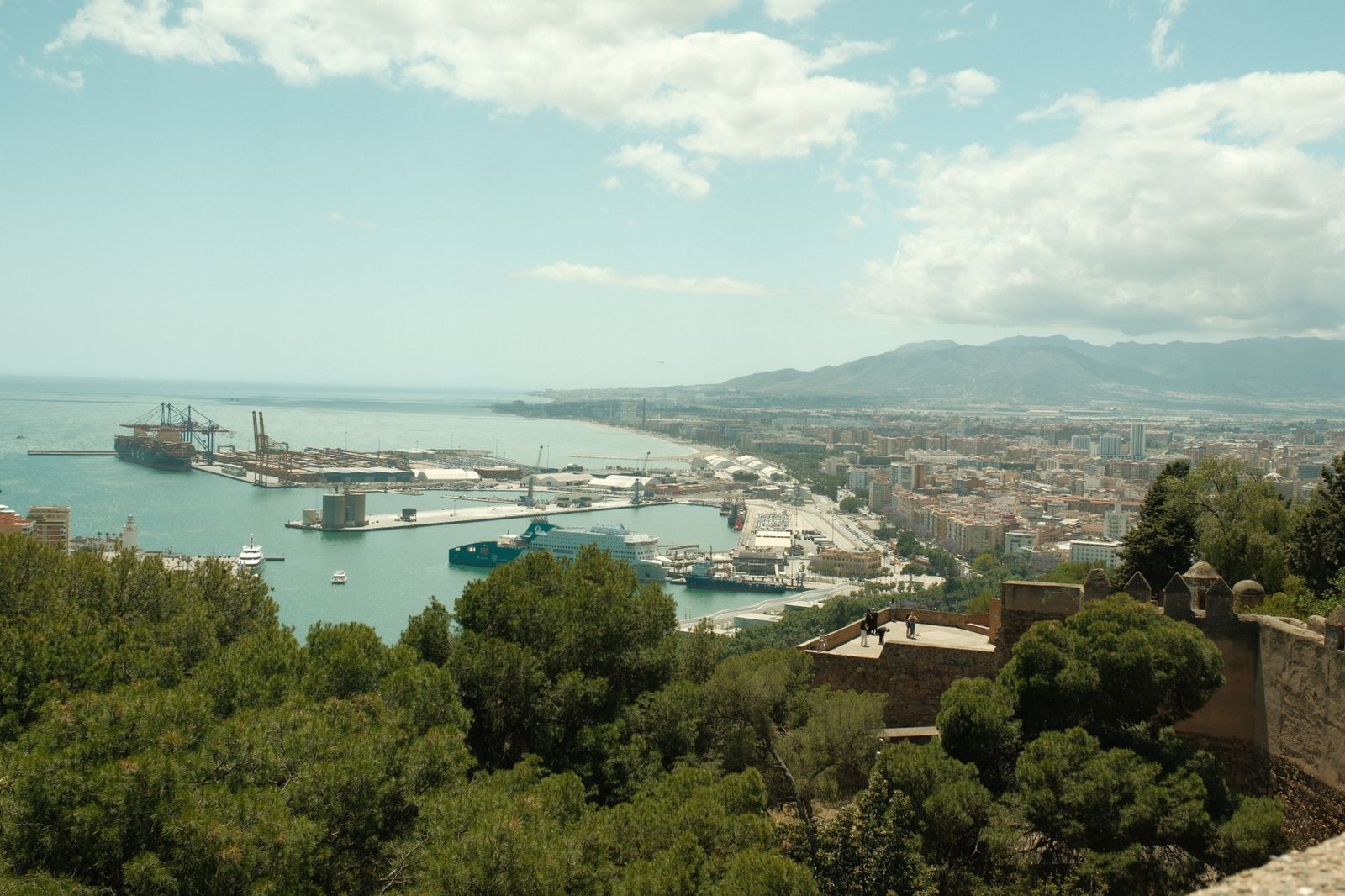 aerial view of Malaga harbor and cityscape under a partly cloudy sky