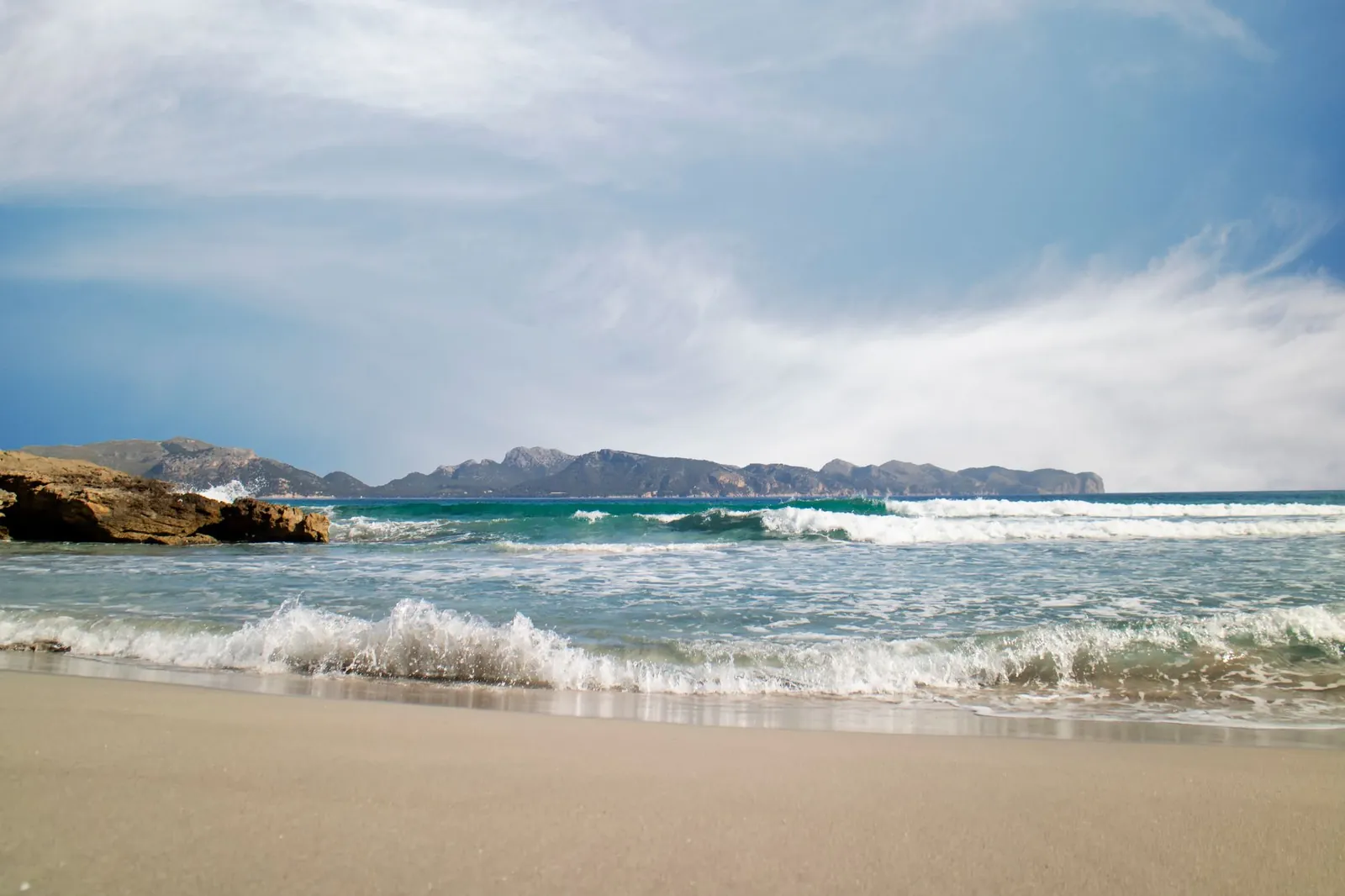 Capture of a beach in Illes Balears, Spain with gentle waves and a clear sky