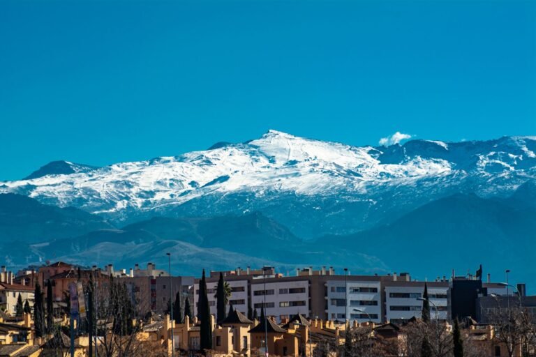 Panoramic view of snowy Sierra Nevada mountains towering over Granada's urban landscape