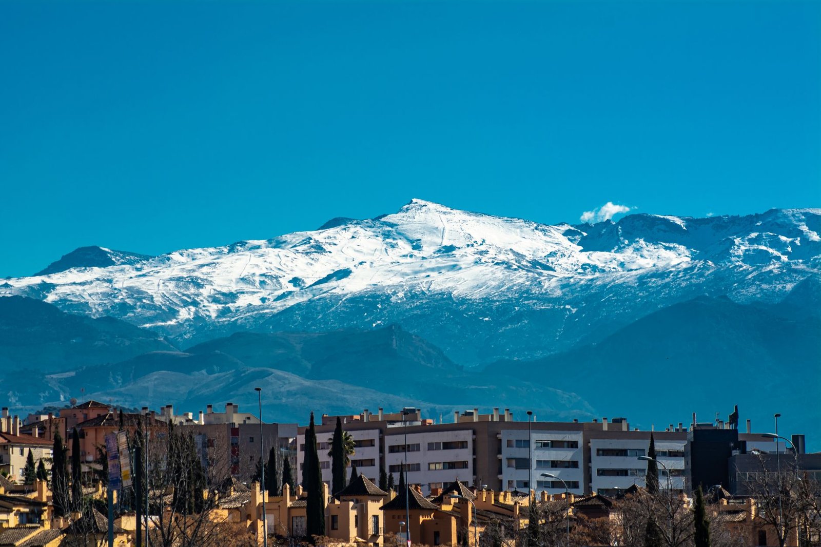 Panoramic view of snowy Sierra Nevada mountains towering over Granada's urban landscape