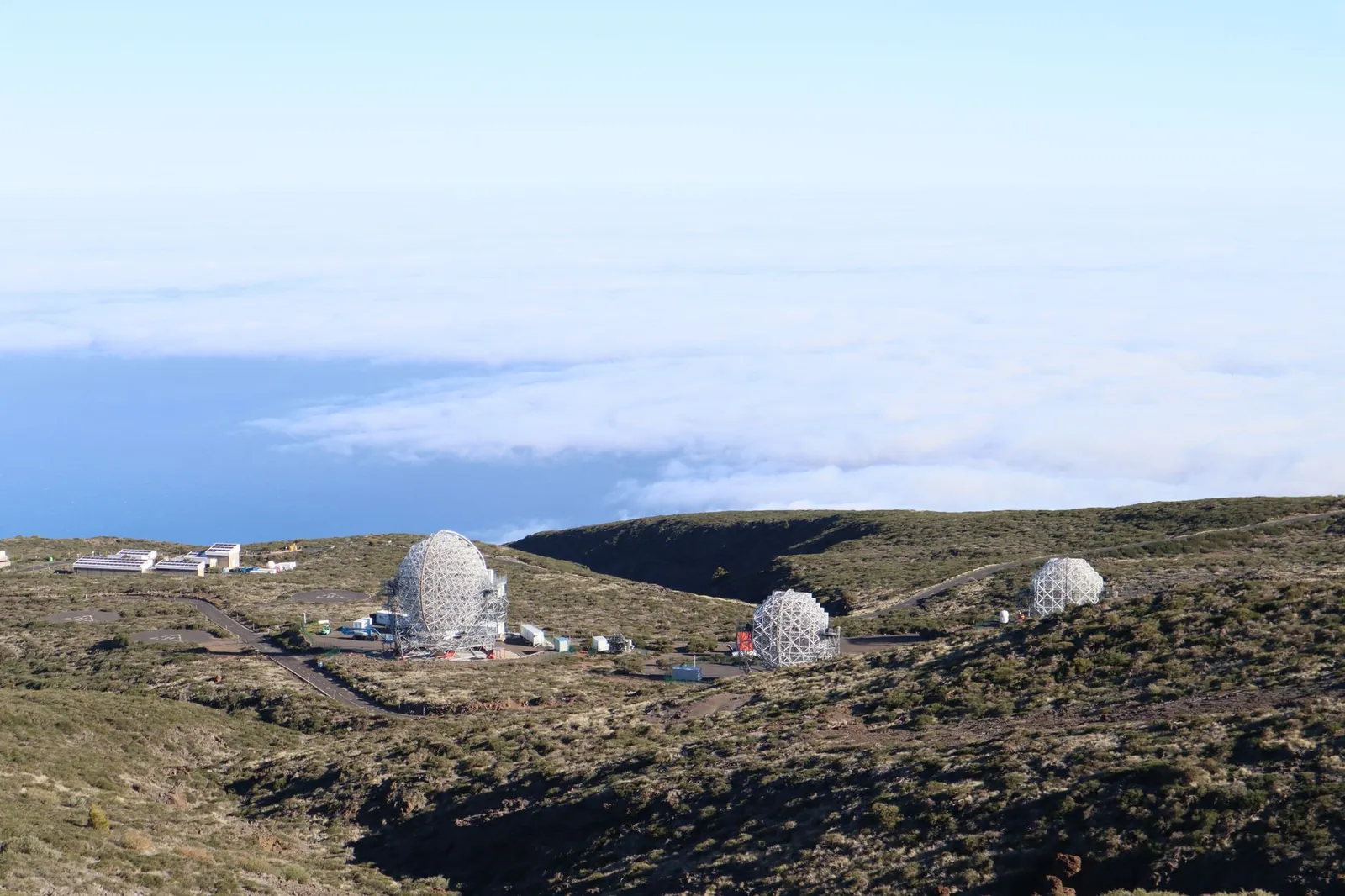 Aerial view of observatories on a rocky landscape by the sea, under open sky