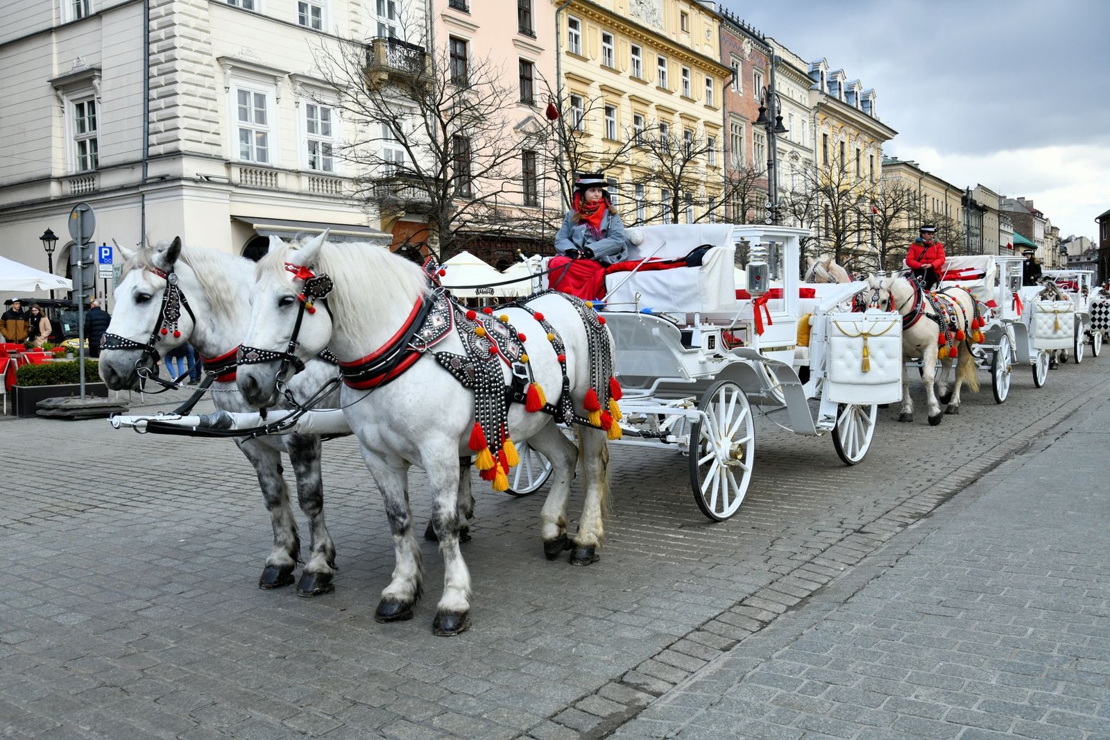 Beautiful horse-drawn carriages on a historic street in Kraków, Poland, perfect capturing the old town charm