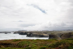 Explore the coastal cliffs of Lugo, Spain with greenery and crashing waves