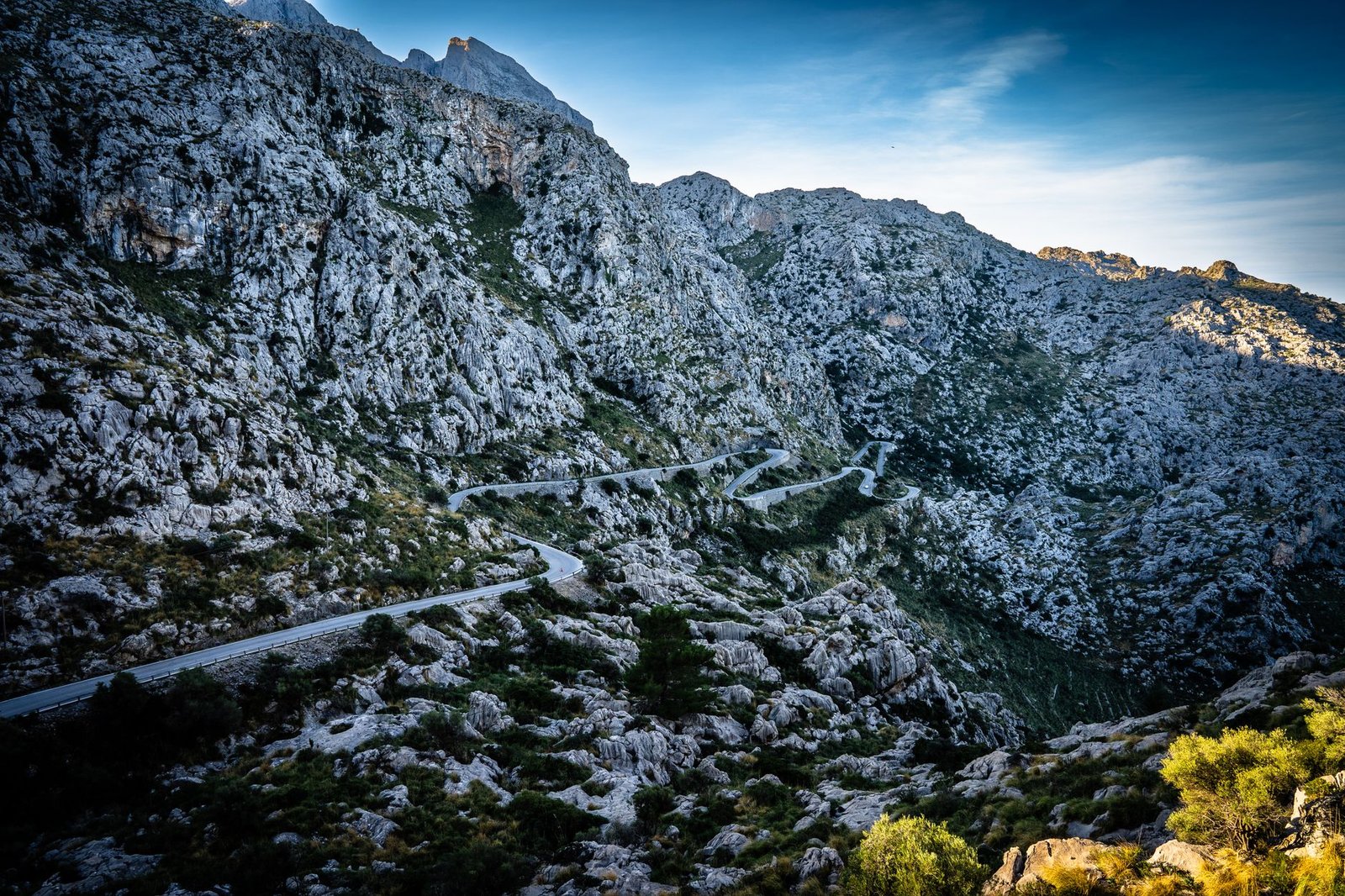 Scenic view of a winding road navigating through a rugged mountain landscape during daytime