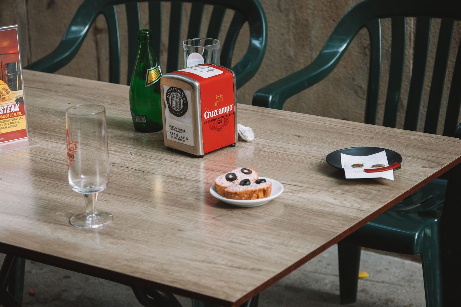Casual outdoor cafe table setting in Valencia, Spain with drink and pastry
