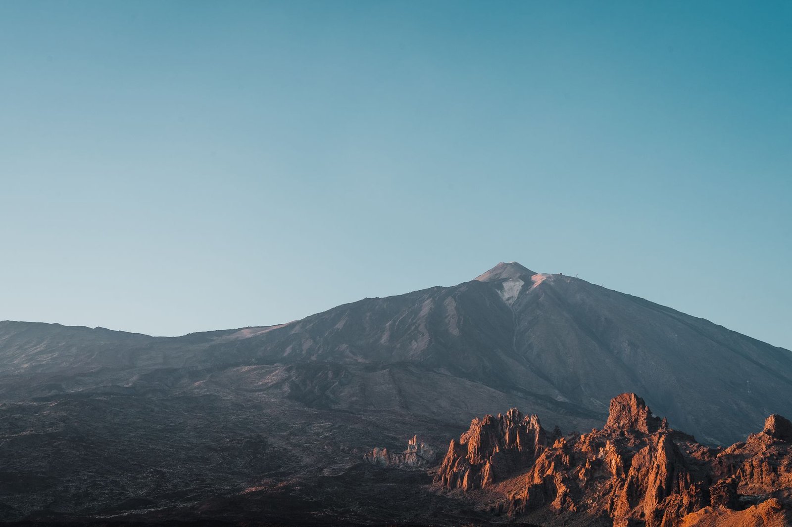 Beautiful landscape of Mount Teide with a clear sky and rocky foreground at sunset