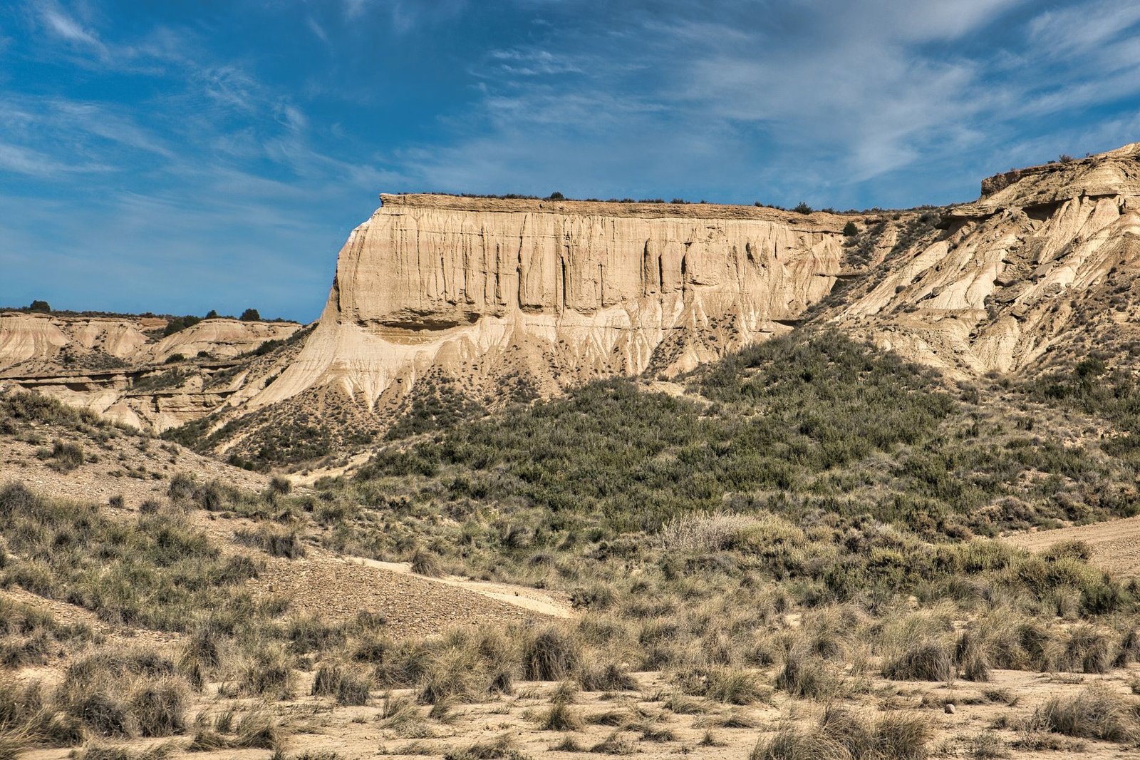 A view of a desert canyon with rugged cliffs under a bright blue sky, perfect for nature enthusiasts