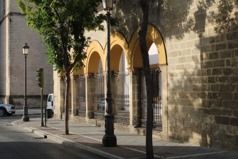 street scene with arched facade and trees in Jerez de la Frontera, Spain, on a sunny day