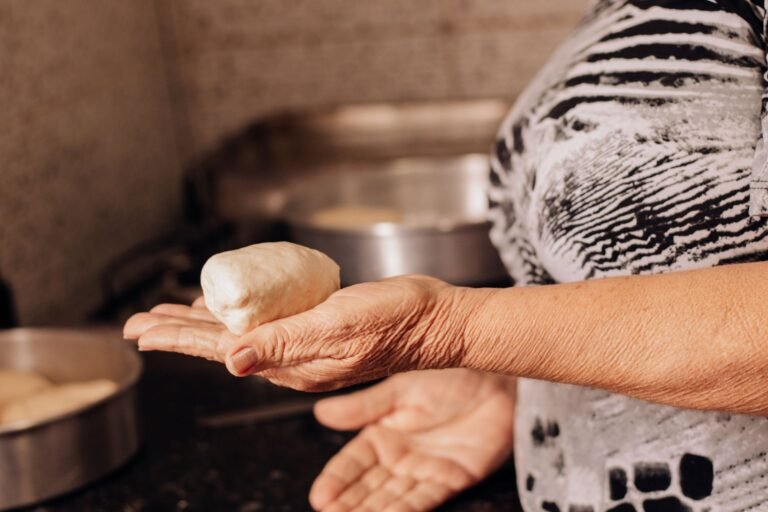 Elderly woman preparing dough in the kitchen, showcasing traditional cooking