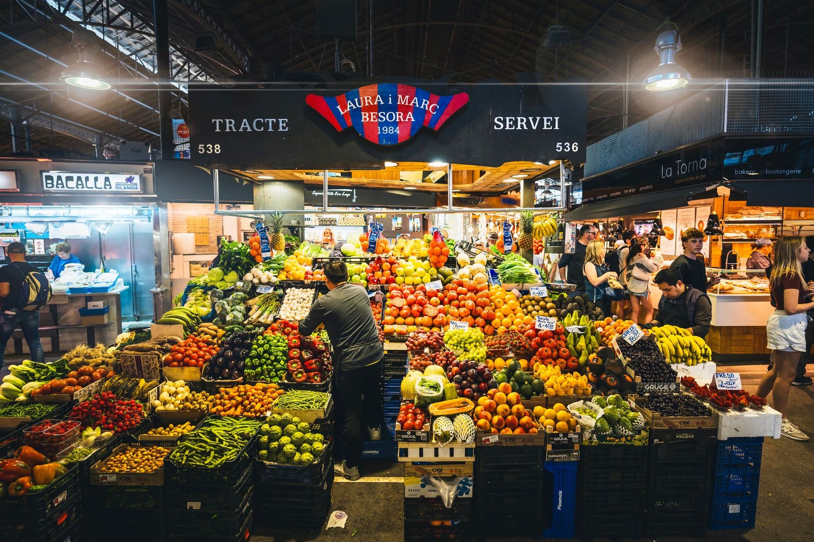 Colorful market stall displaying fresh fruits and vegetables in Barcelona's market