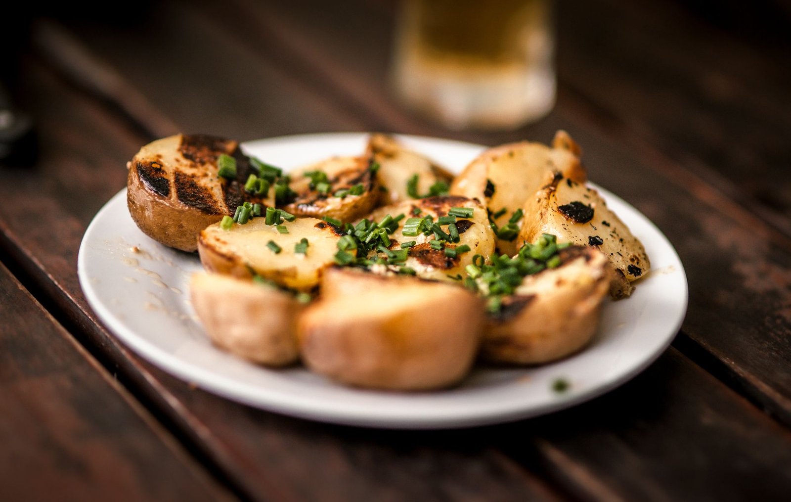 Delicious grilled potatoes garnished with fresh chives, perfect for a rustic meal
