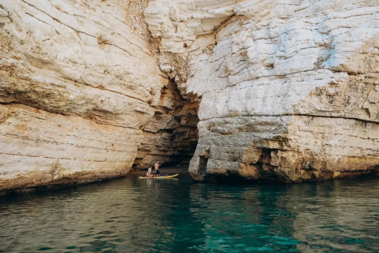 Kayakers explore a limestone cave in Vieste, Puglia, during summer
