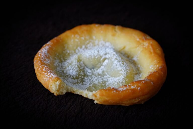 A delicious pastry topped with powdered sugar, showcasing a rustic homemade look