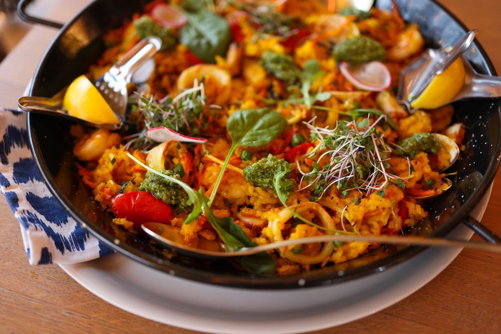 Delicious paella with seafood, vegetables, and herbs in a pan, ready to serve