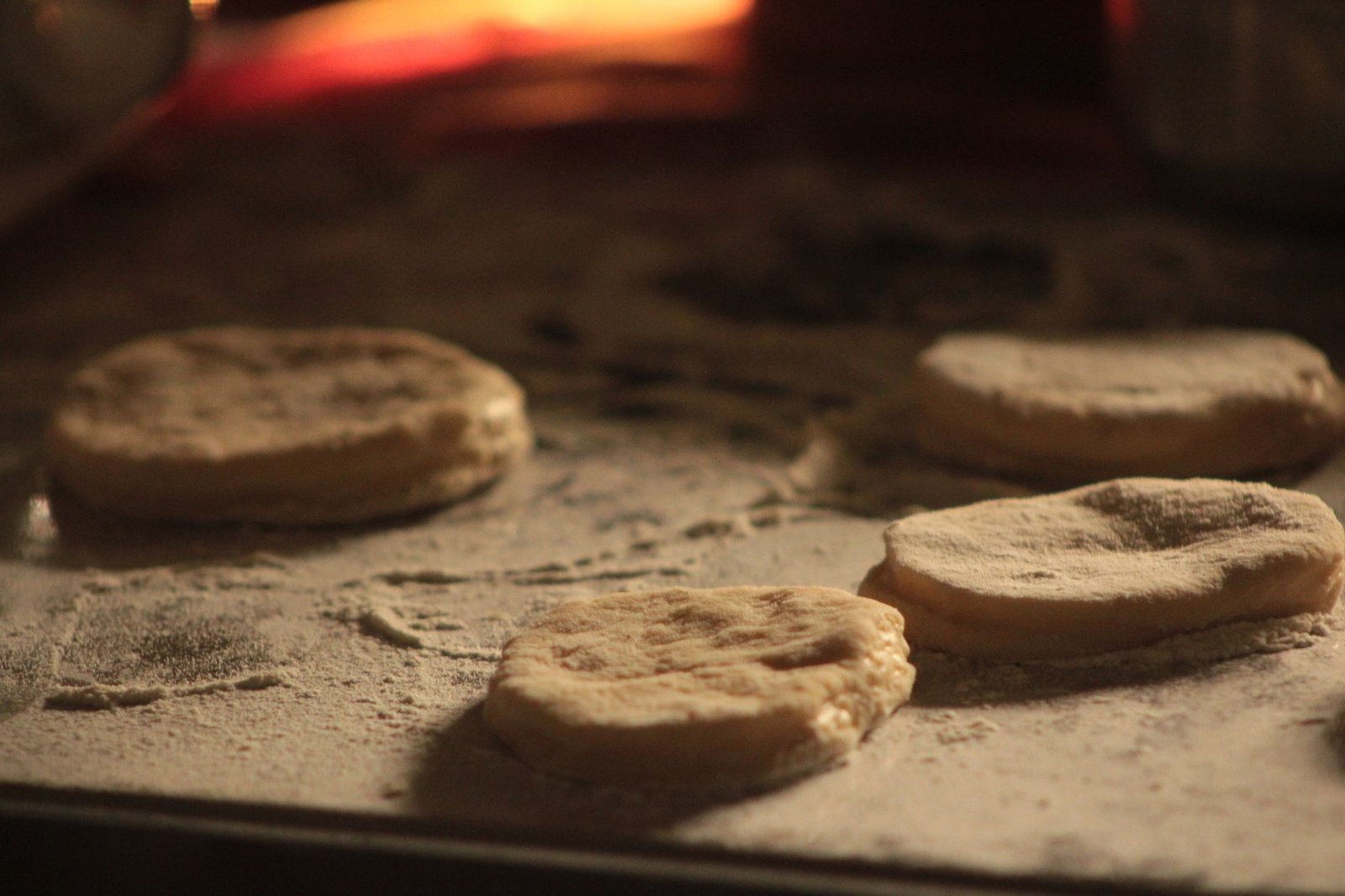 Close-up view of biscuit dough pieces on a flour-dusted surface, ready to bake