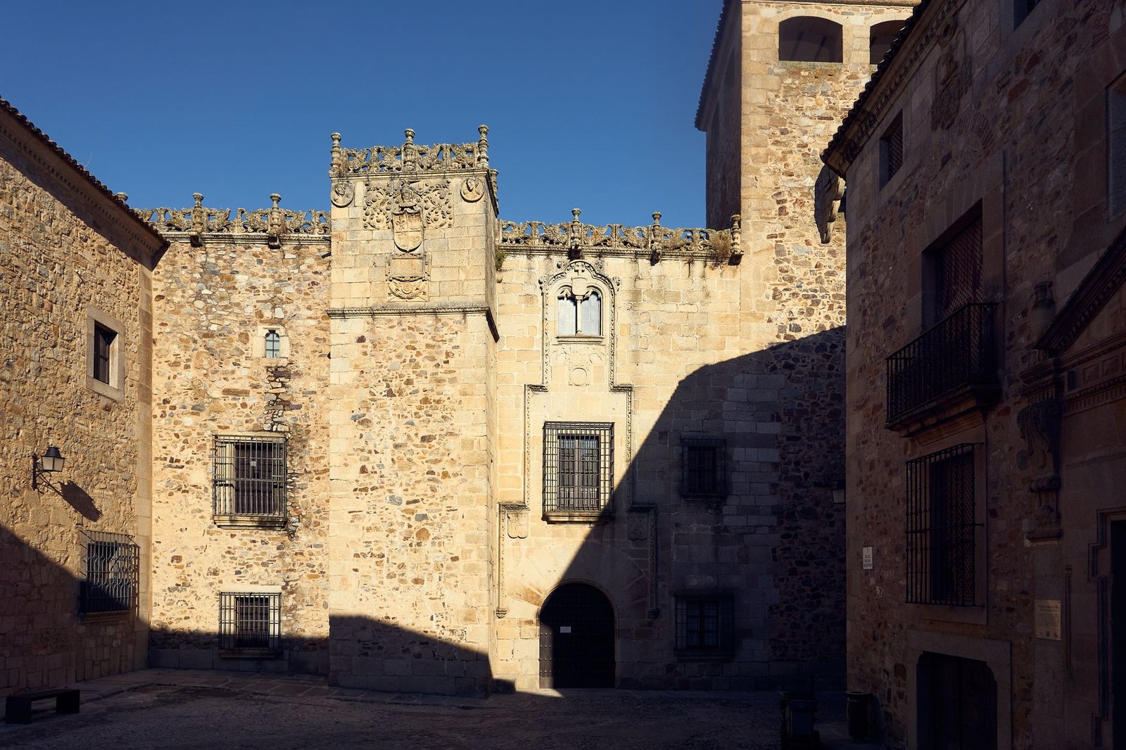Sunlit stone building in a European courtyard, showcasing medieval architecture