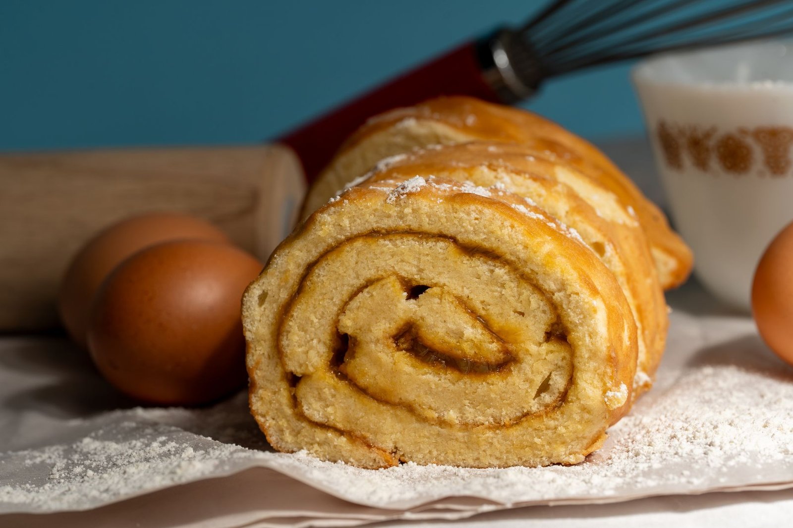 Close-up of a freshly baked roll cake with baking ingredients