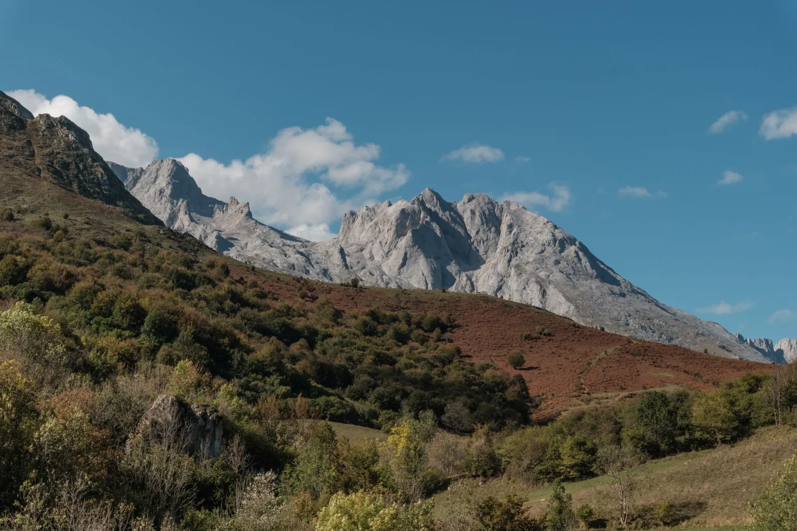 Explore the mountain landscape in Asturias, Spain with greenery and clear skies