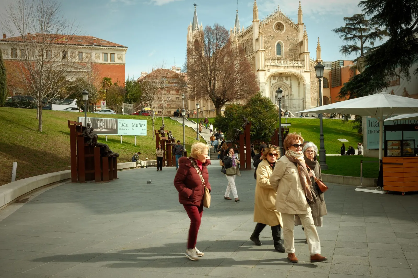 Group of adults walking near the historical San Jerónimo el Real Church in Madrid, Spain
