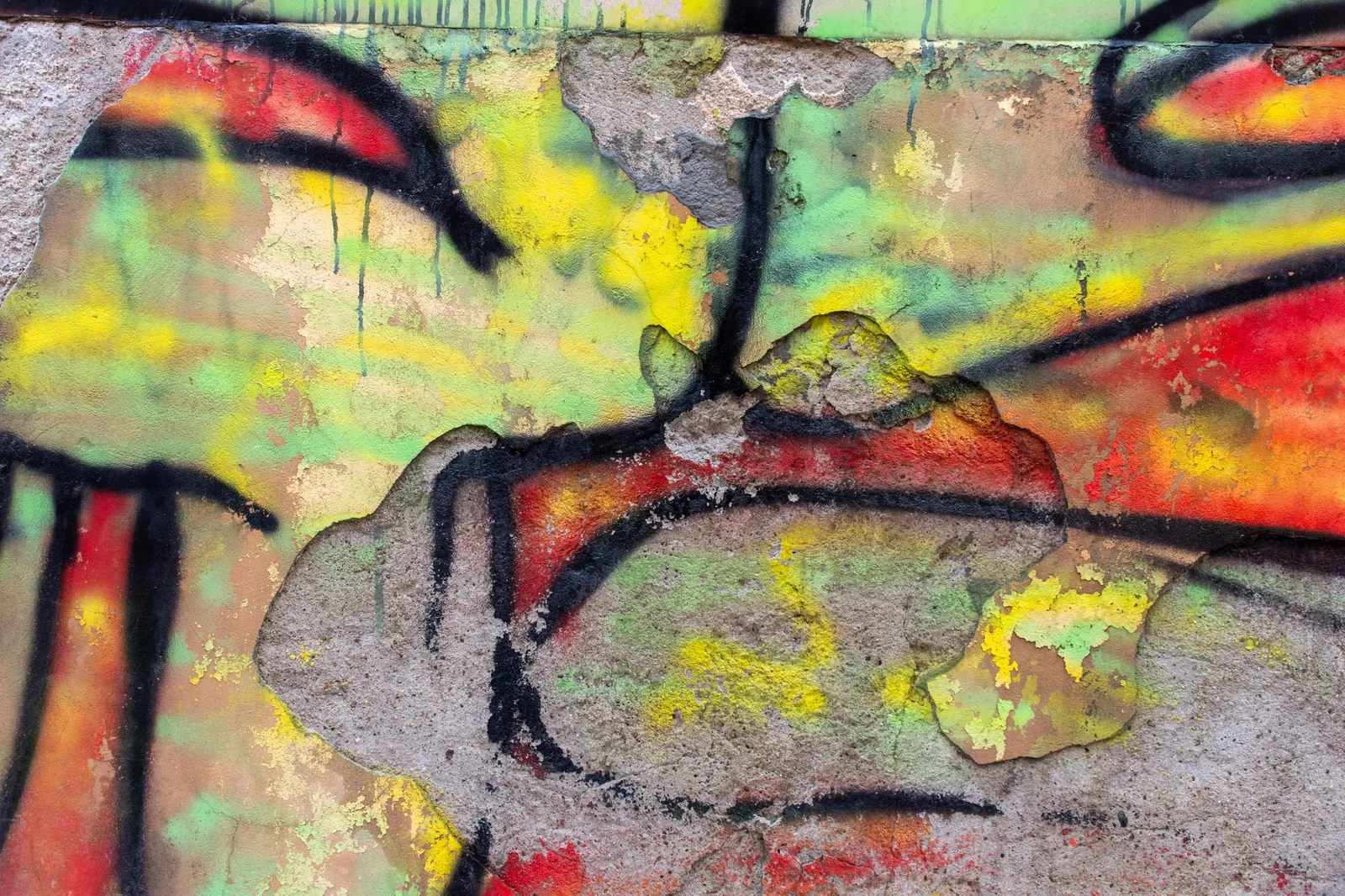 graffiti on a weathered wall with peeling paint, showcasing artistic street art