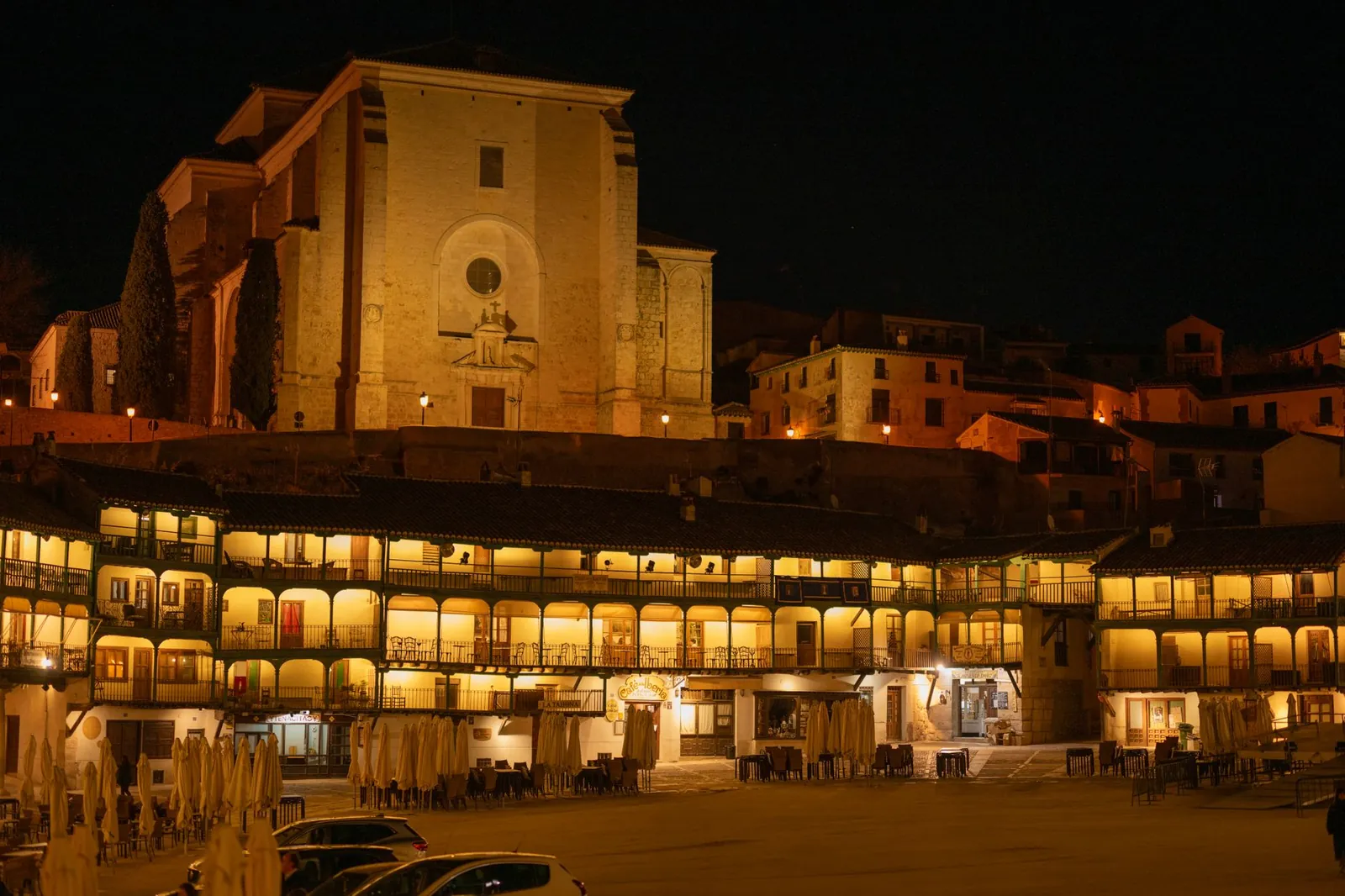 Night view of the illuminated Plaza Mayor and Church of Our Lady of Assumption in Chinchón, Spain