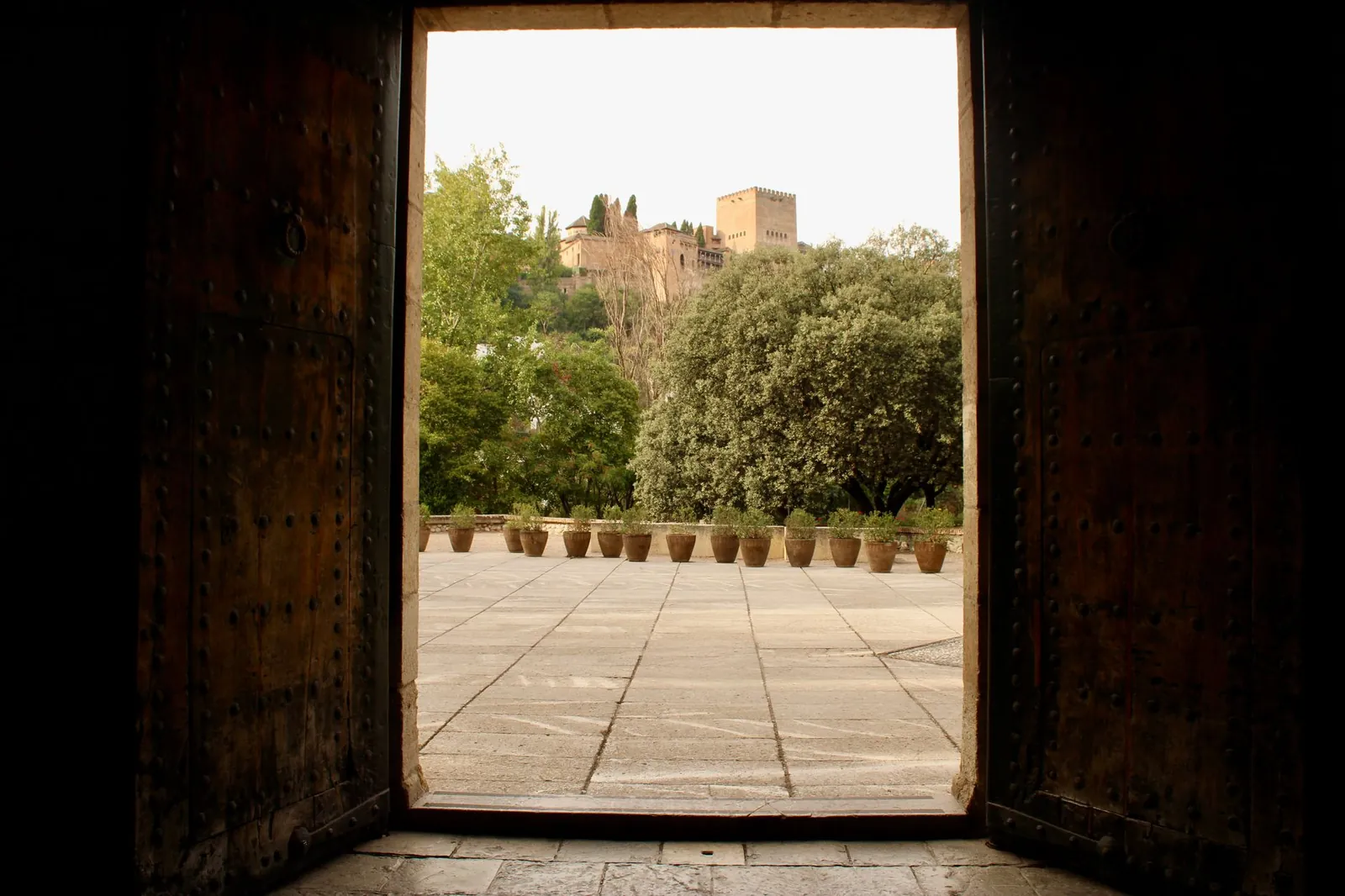 Capture an iconic view of Alhambra from indoors through ancient doors in Granada, Spain