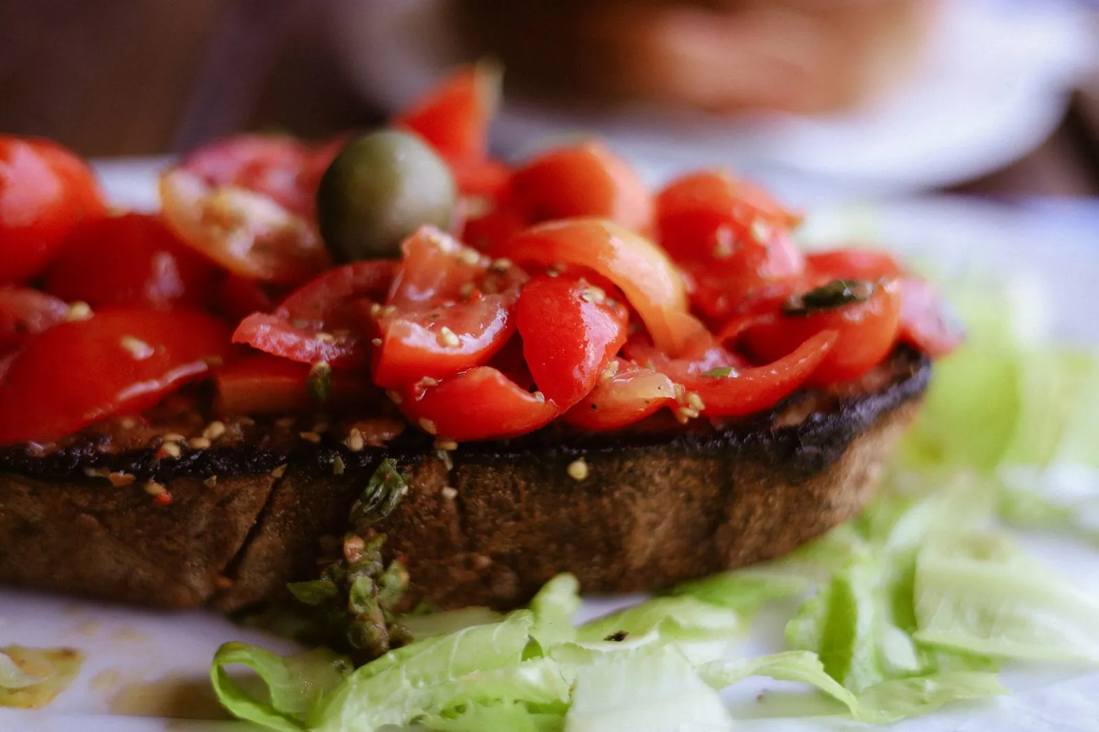 Close-up of traditional Italian bruschetta topped with cherry tomatoes and an olive