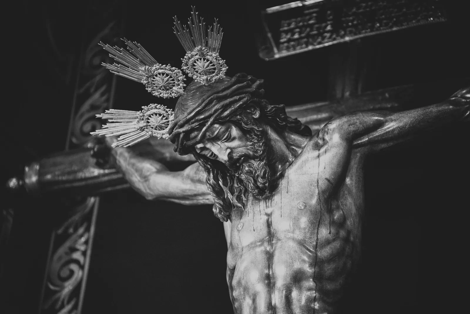 Black and white sculpture of Jesus Christ on the cross located in a Seville church