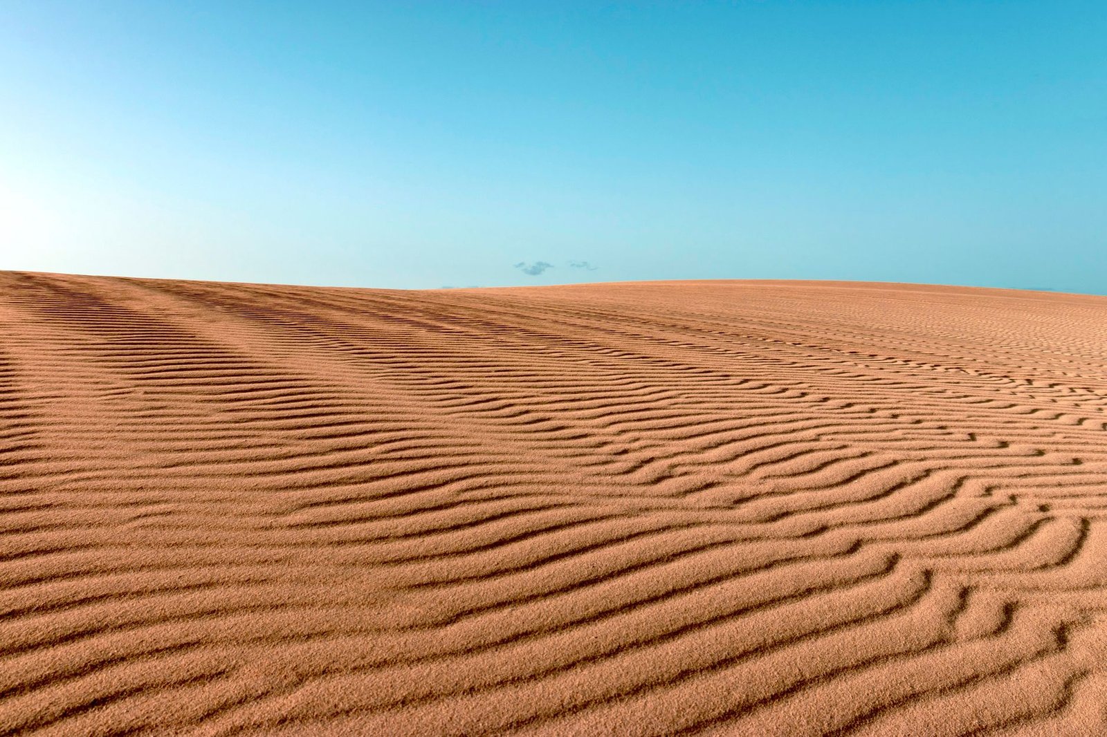 desert landscape with rippled sand dunes under a blue sky in Spain