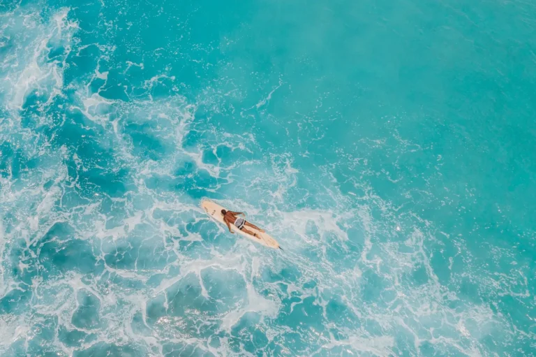 Aerial shot of a paddleboarder on the turquoise sea, capturing the essence of ocean relaxation