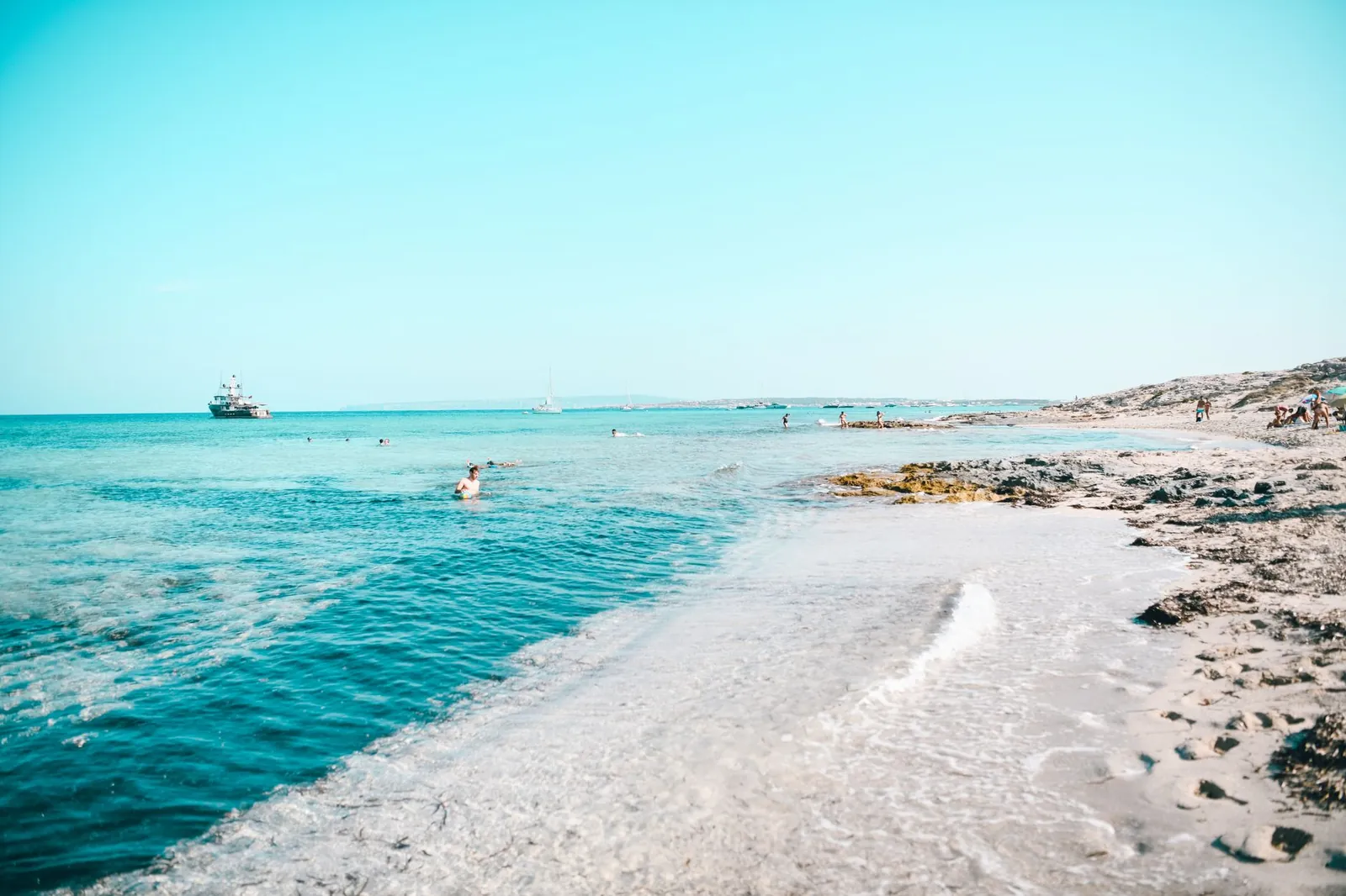 Relaxing beach scene in Formentera, Spain with clear blue waters and a horizon