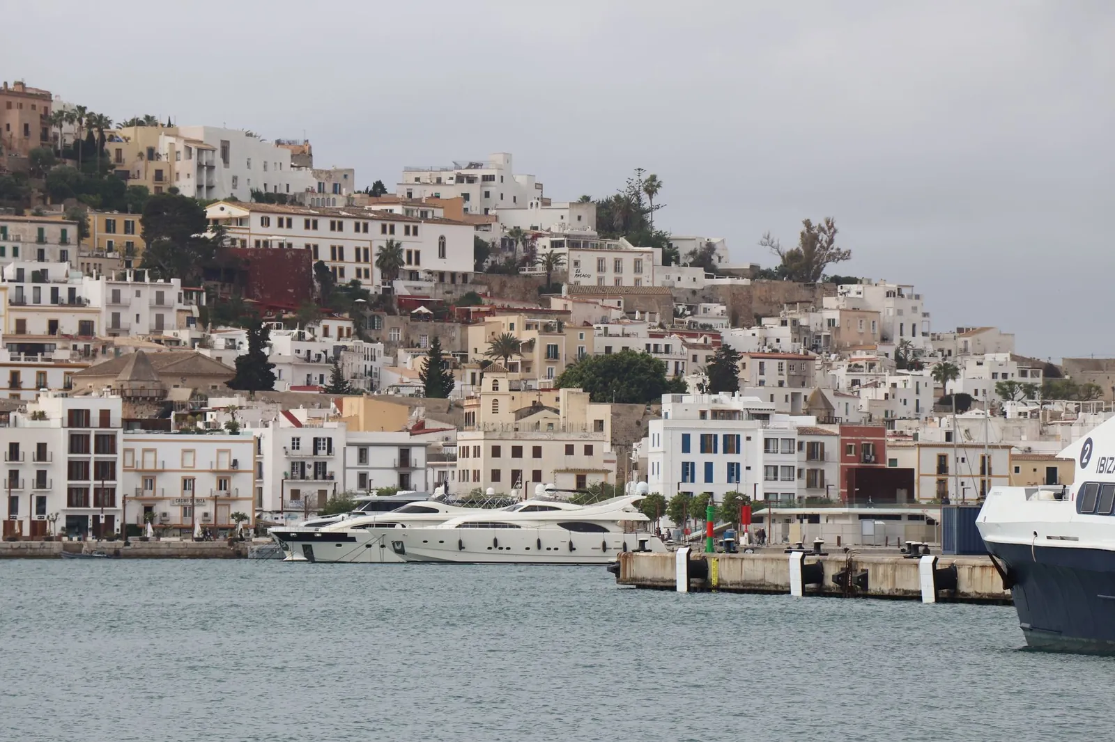 Panoramic view of Ibiza's old town architecture and luxury yachts in the marina, Balearic Islands